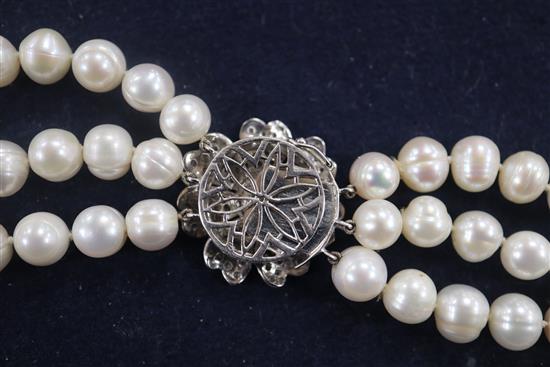 A triple strand freshwater? pearl necklace with white gold and diamond cluster set clasp, 68cm.